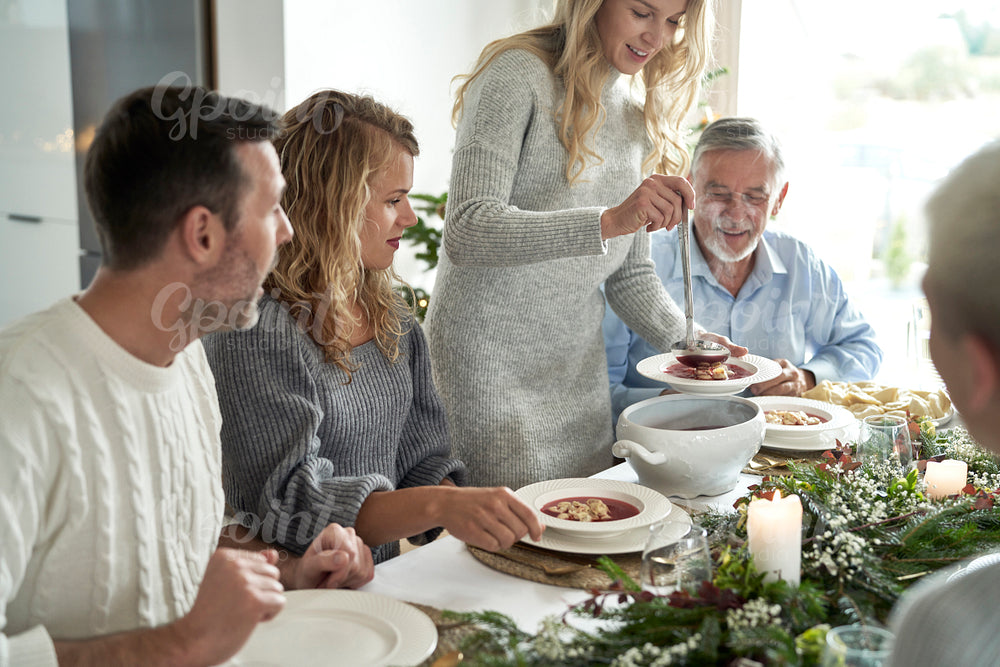Caucasian family start eating traditional Polish soup at Christmas Eve 