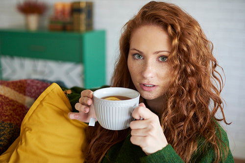 Portrait of beautiful woman drinking tea at home