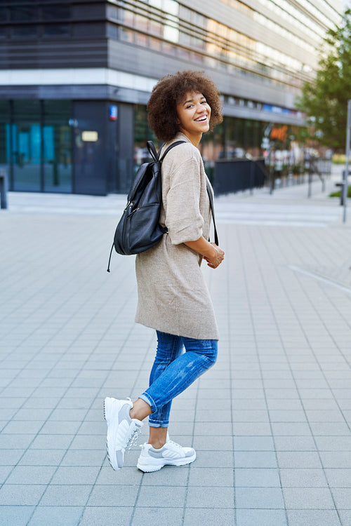 Smiling woman with backpack outdoors