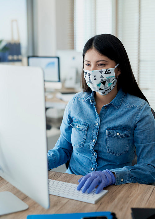 Woman working in protective gloves and mask in the office