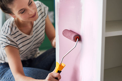 Close up of young woman repainting furniture