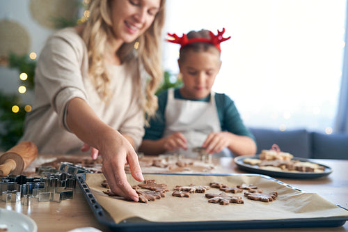 Caucasian woman with daughter making cookies in Christmas time in the kitchen