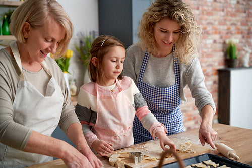 Happy three generations of women making Eater cookies at home