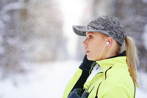 Side view of female athlete listening to music