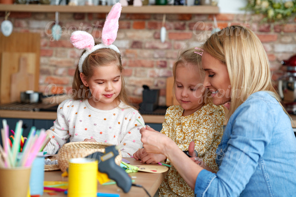 Mom with her daughters preparing Easter decorations at home