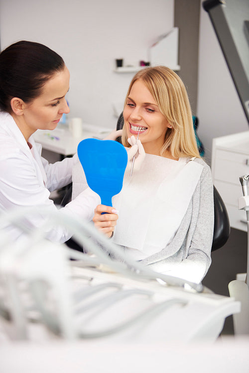 Female dentist examining woman's teeth during dental checkup