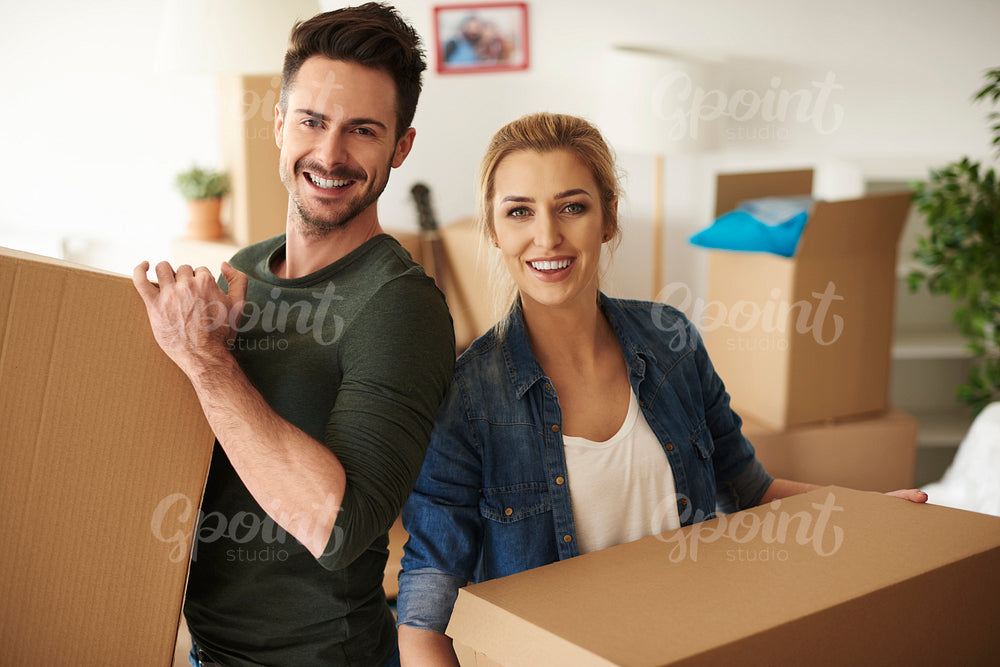 Portrait of couple holding cardboard boxes
