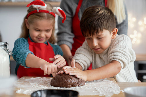 Children preparing pastry for gingerbread cookies