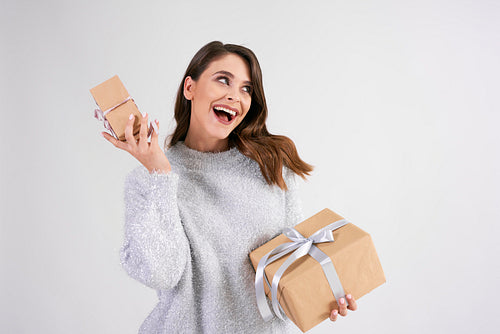 Happy woman holding two gifts in studio shot
