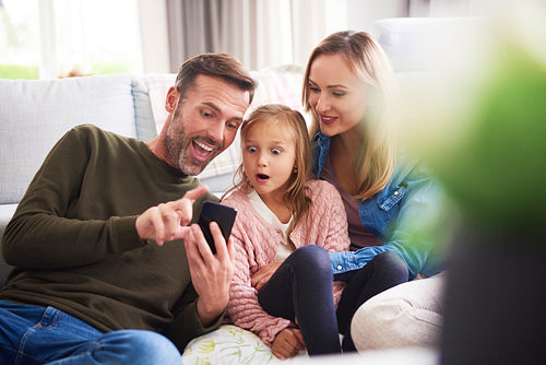 Family with mobile phone in living room