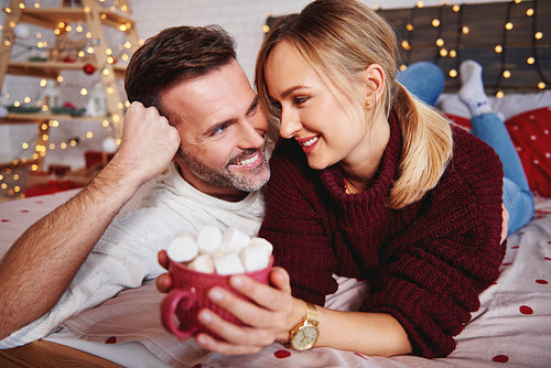 Smiling man embracing his girlfriend in Christmas