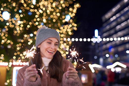 Attractive woman with sparklers on Christmas market