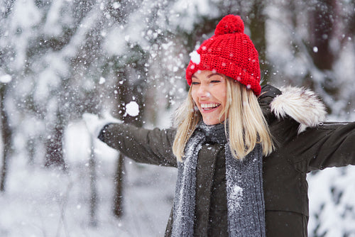 Happy woman dancing among snowflake