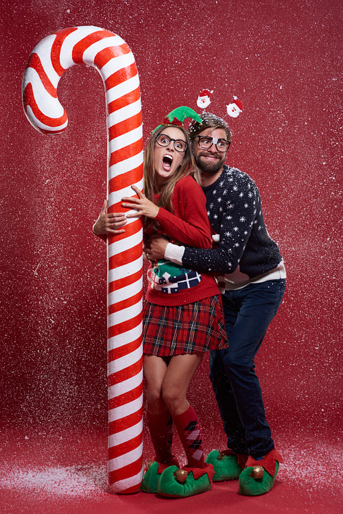 Couple next to a huge candy cane