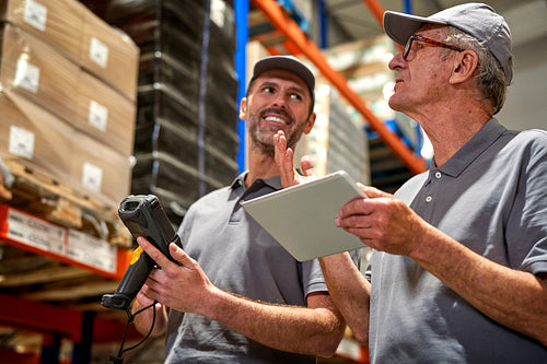 Two caucasian men in mature age discussing together in warehouse