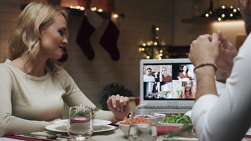 Family spending Christmas Eve with friends by video chat