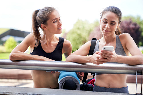 Two women with mobile phone waiting for training