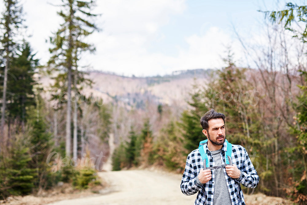 Front view of hiking man with backpack admiring at view