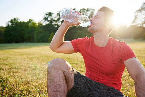 Drinking water and resting after workout on the fresh air