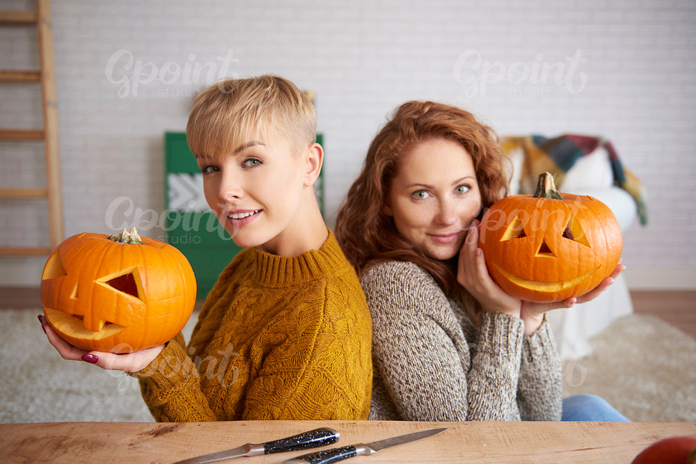 Portrait of happy girls holding pumpkins