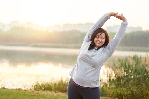 Smiling woman stretching her arms