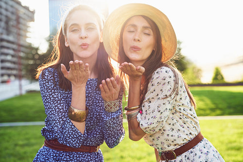 Young beautiful two woman blowing a kiss