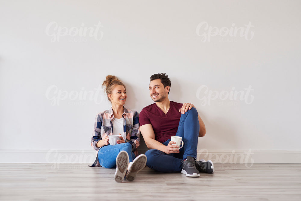 Smiling couple with coffee taking break from moving home