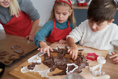 High angle view of children cutting out gingerbread cookies