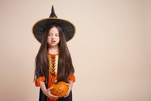Little witch with halloween pumpkin
