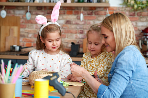 Mom with her daughters preparing Easter decorations at home