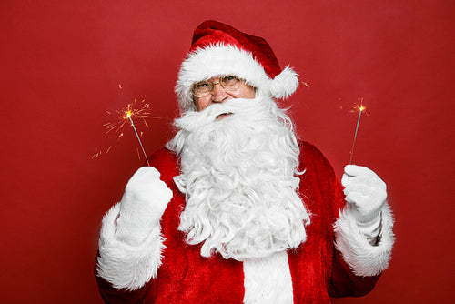 Caucasian Santa Claus holding Christmas sparklers