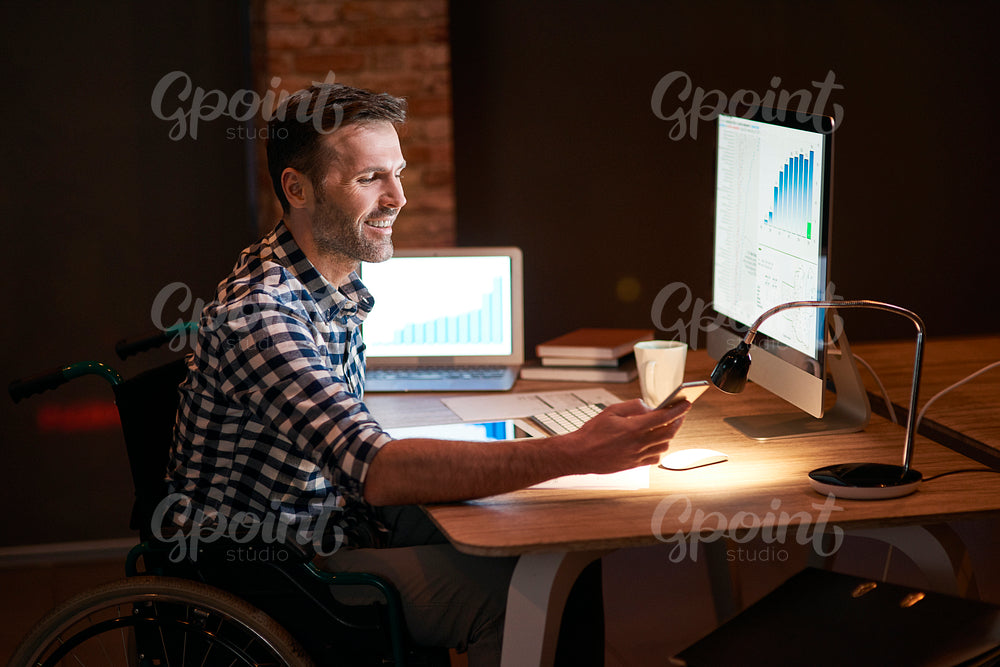 Disabled man working with technology at night