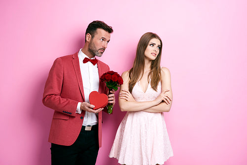 Man with bunch of rose and chocolate box apologizing fiancée