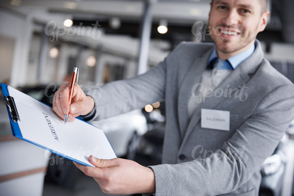 Front view of salesman with agreement