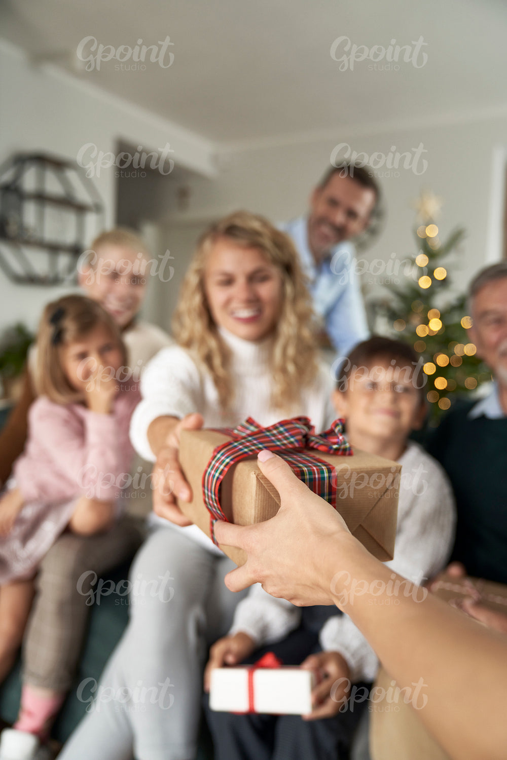 Unrecognizable caucasian person giving Christmas present to a woman