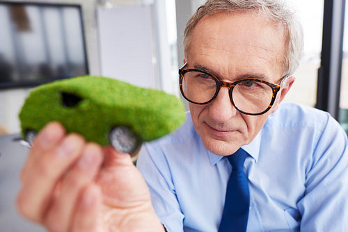 Businessman looking at eco friendly car