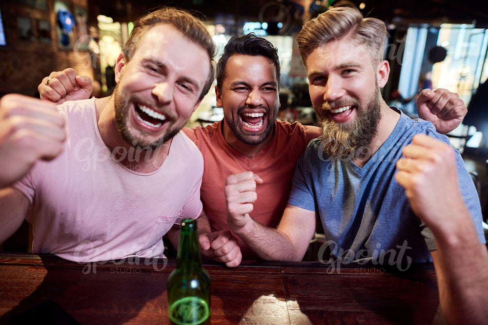 Portrait of three screaming men in the pub