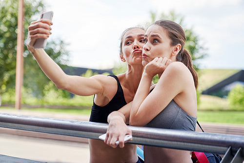 Two athletic women making funny faces for selfies