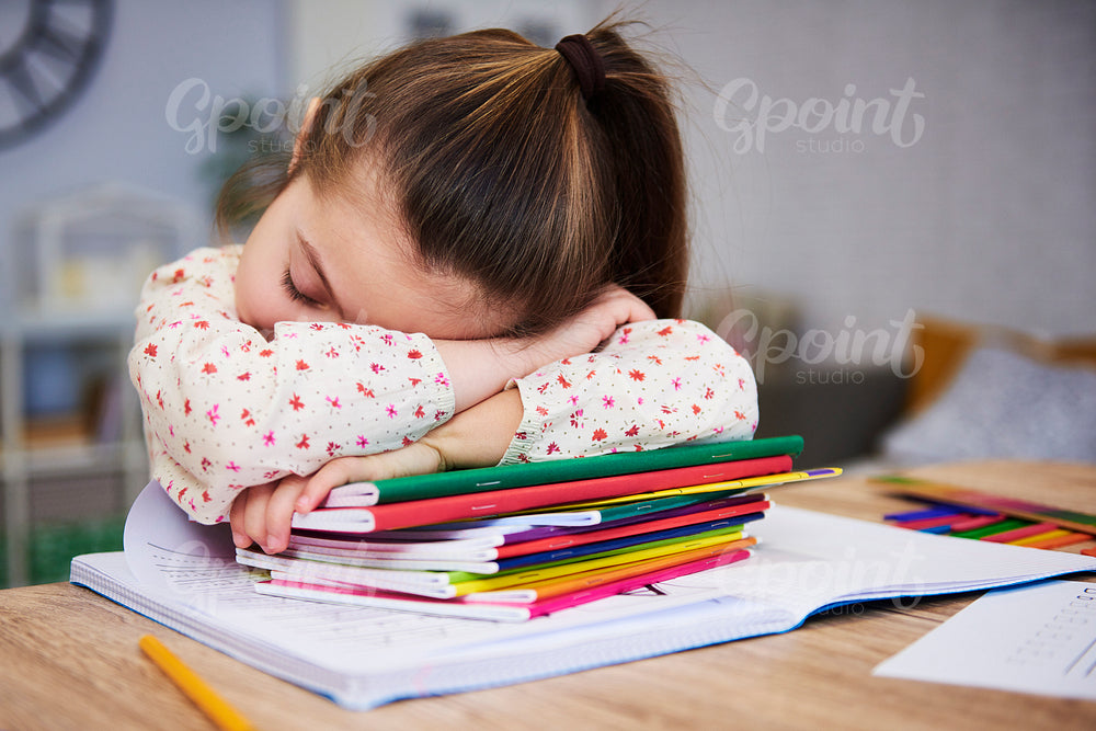 Tired and bored child sleeping on books