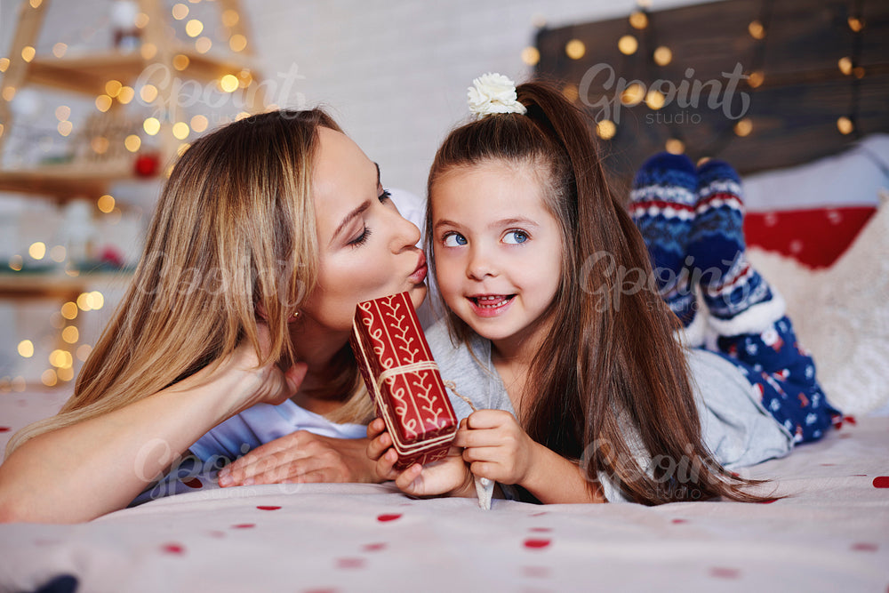 Cute girl giving christmas present to her mom