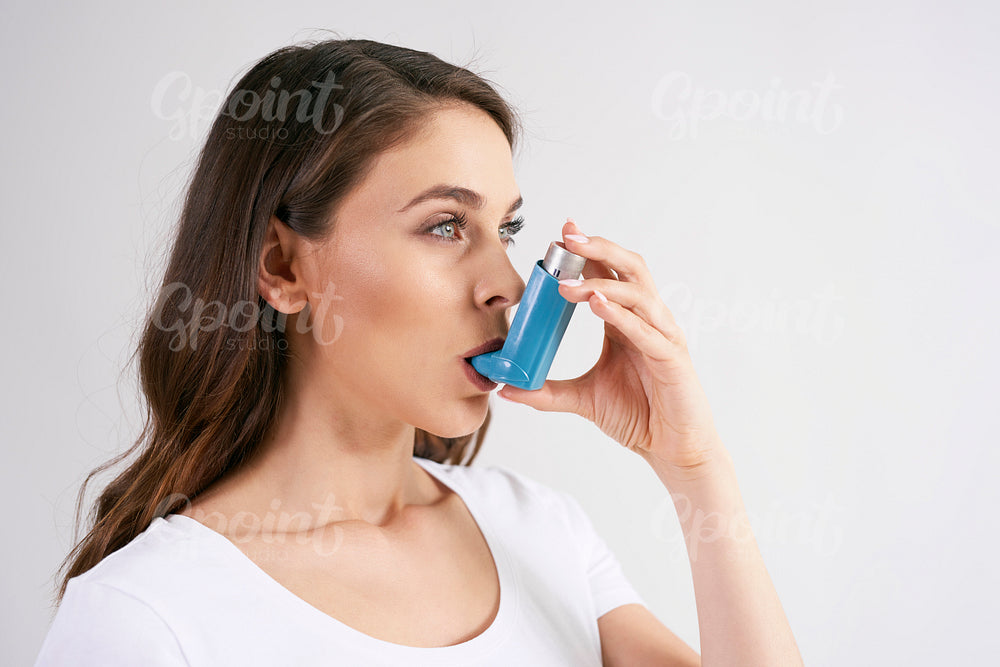 Asthmatic woman using an asthma inhaler during asthma attacks