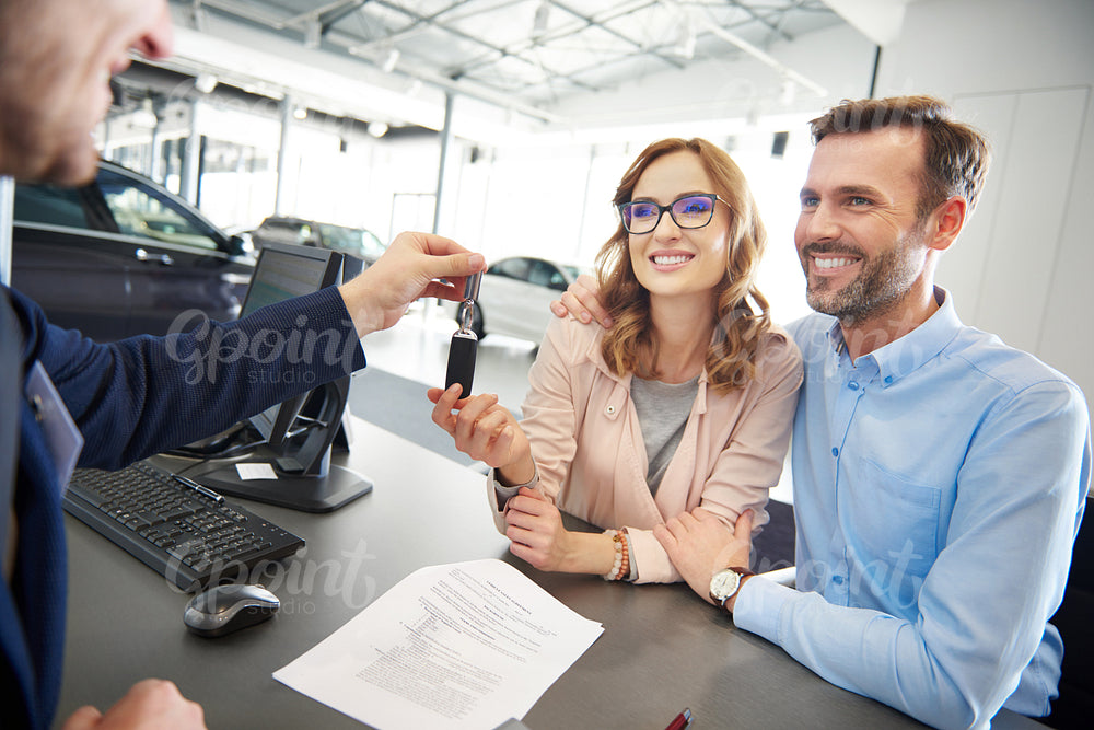 Excited couple receiving car keys