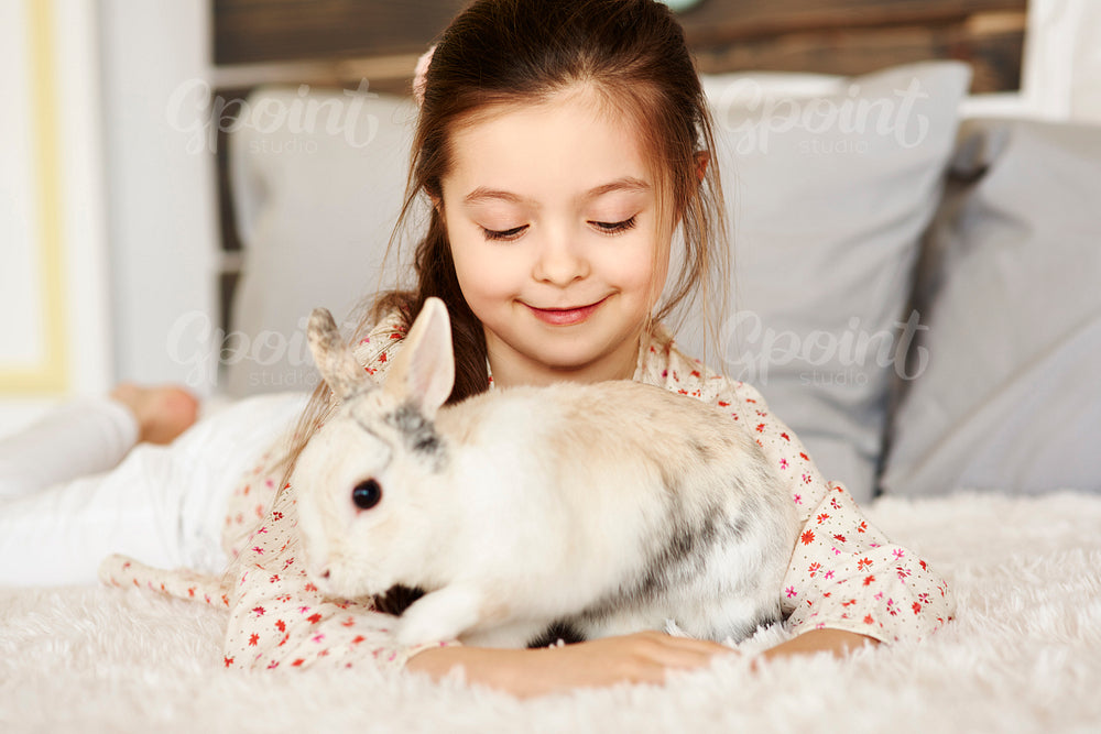 Affectionate girl playing with rabbit