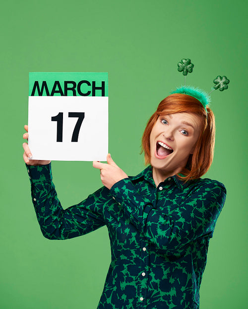Woman holding calendar with a date for Saint Patrick's Day