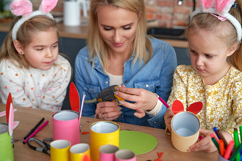 Close up of mom with two girls preparing Easter decorations
