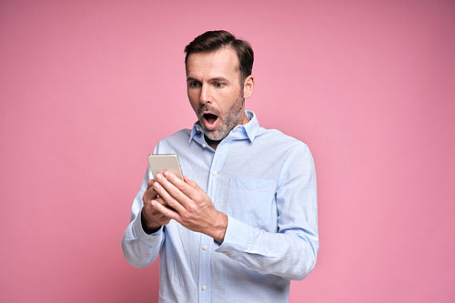 Shocked man holding mobile phone