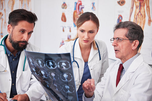 Three busy doctors discussing some medical records
