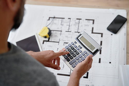 Architect using a calculator to calculate the usable area