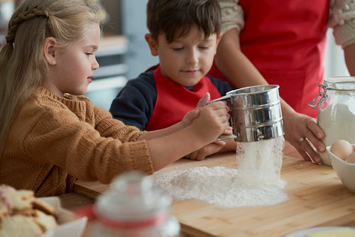 Children helping mother with baking Christmas cookies