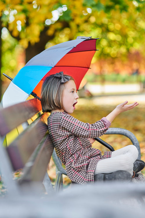 Child looking for shelter with umbrella